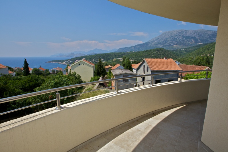 Balkon mit Panoramablick auf das Meer und die Berge in einem Haus in der Stadt Utjeha, Montenegro: Fliesenboden und Metallgeländer.