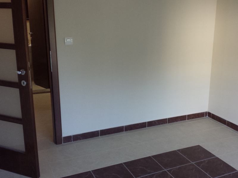 Helles Wohnzimmer in einer Wohnung in Pržno, Montenegro: Fliesenboden mit Dekor, Innentür mit Milchglas.