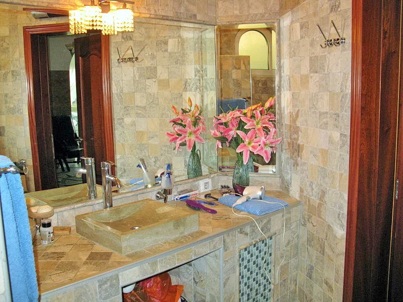 Bathroom with natural stone finishes in a villa in Dobra Voda, Montenegro: stone sink and mirror.