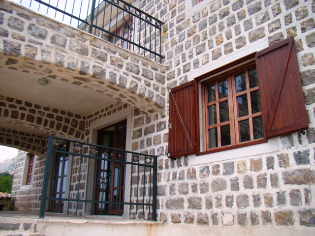 Karadağ, Petrovac şehrinde doğal taş cepheli, ahşap panjurlu ve ferforje balkonlu ev.