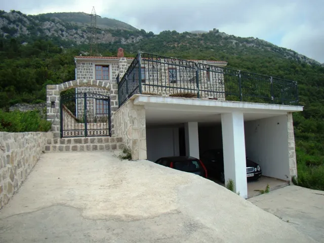 Steernes zweistöckiges Haus mit Garage und Balkon in der Nähe eines Berges