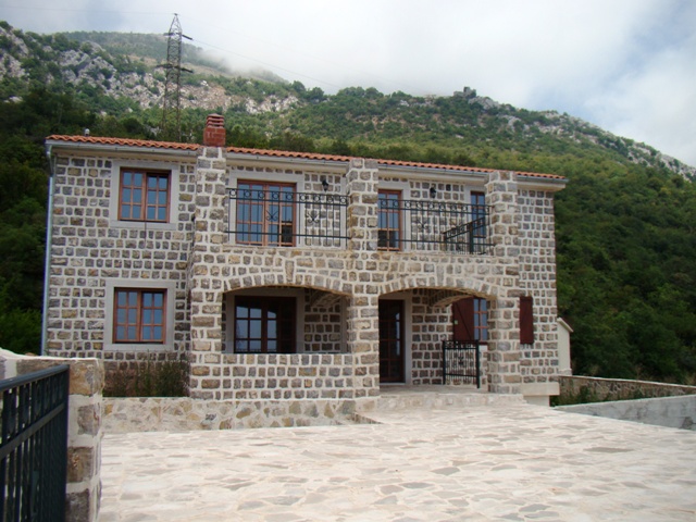 Terasta ve balkonu olan, dağlarda doğal taştan iki katlı ev, Petrovac şehri, Karadağ.