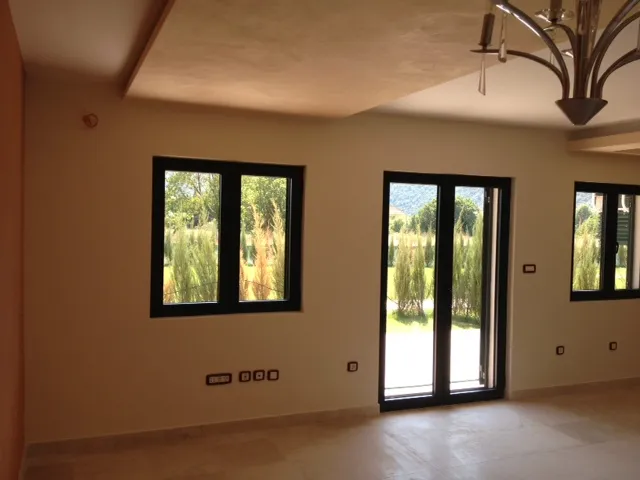 Helles Wohnzimmer in einer Wohnung in Budva, Montenegro: Panoramafenster, moderne Ausstattung und ein Designer-Kronleuchter.