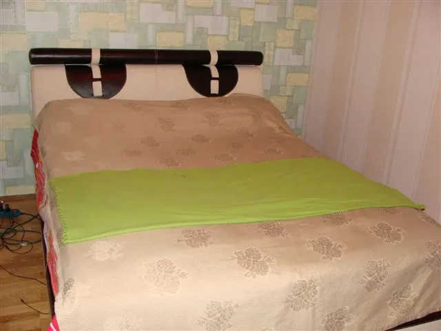 Doppelbett mit gepolstertem Kopfteil im Schlafzimmer einer Wohnung in Budva, Montenegro.