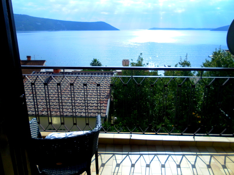 Balkon sa pletenim nameštajem i panoramskim pogledom na more u kući, Herceg Novi, Crna Gora.
