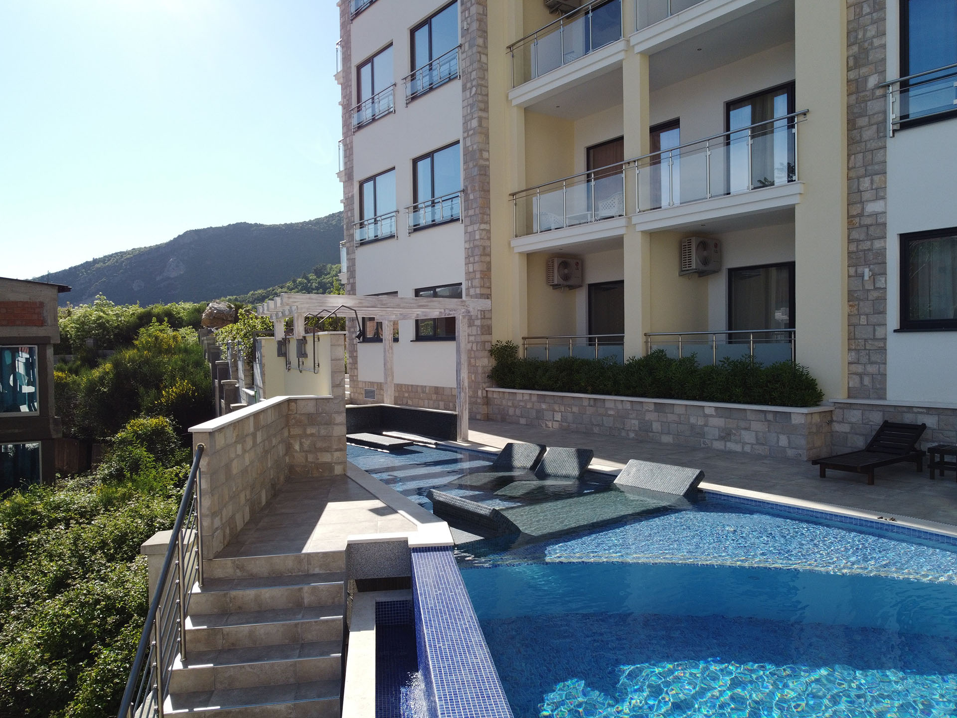 MonteDreams konut kompleksinde şezlonglu yüzme havuzu, Bečići, Budva Rivierası, Karadağ.