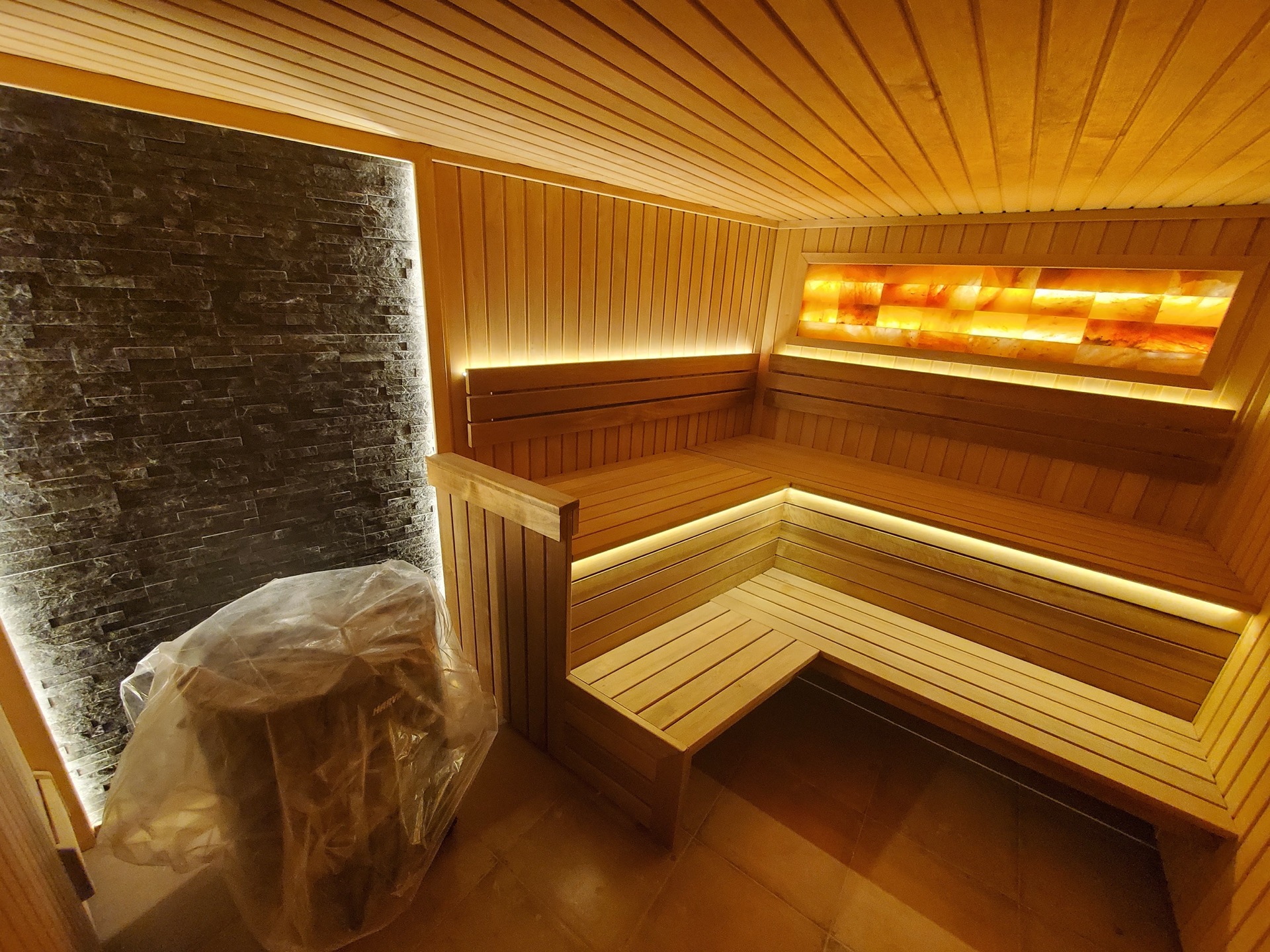 MonteDreams konut kompleksinde, Bečići, Karadağ’da ahşap kaplamalı, Himalaya tuzu aydınlatmalı ve taş duvarlı modern sauna
