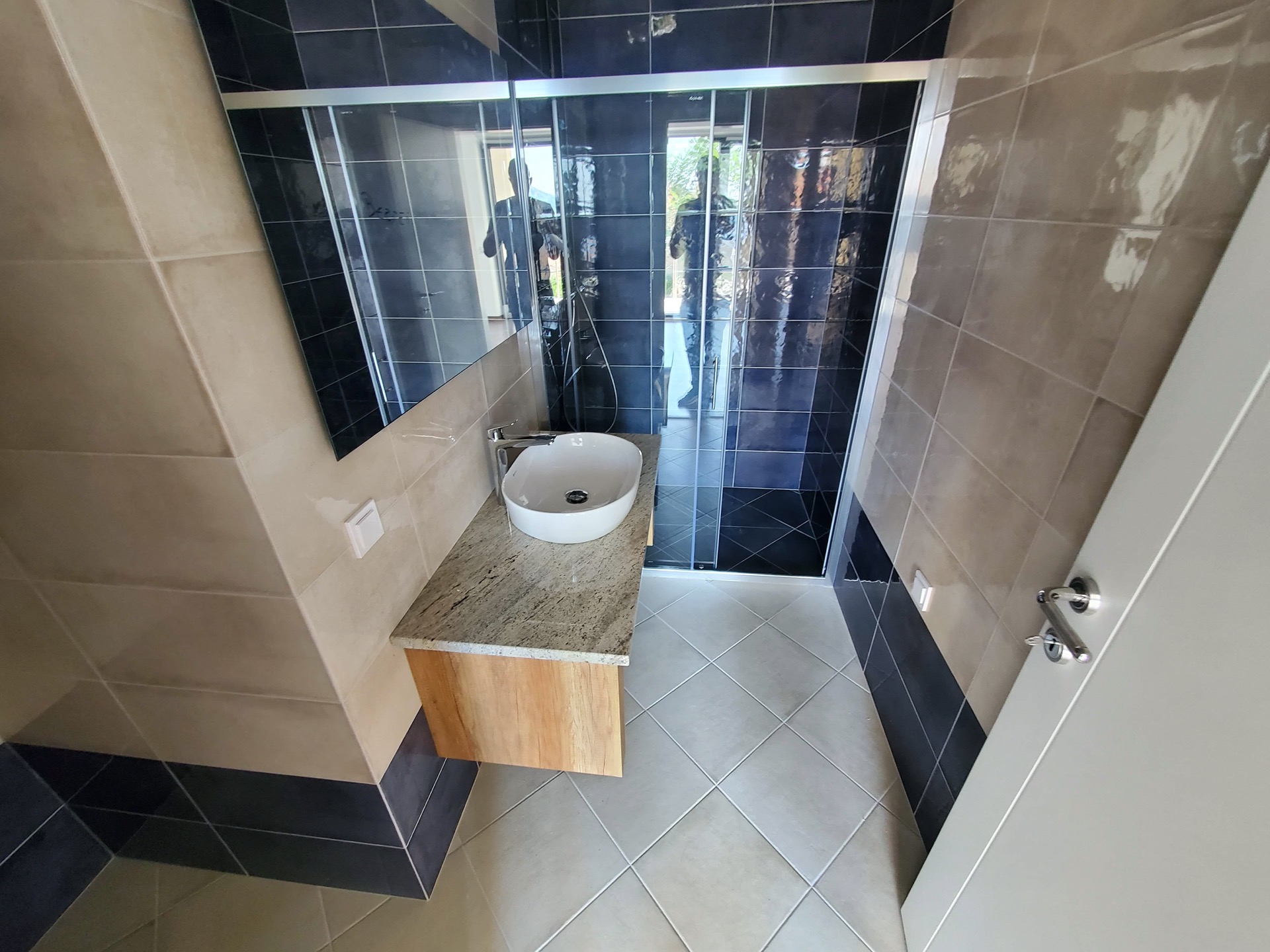 MonteDreams konut kompleksinde, Bečići, Karadağ’da duş kabinli modern banyo: şık kaplama ve sıhhi tesisat.