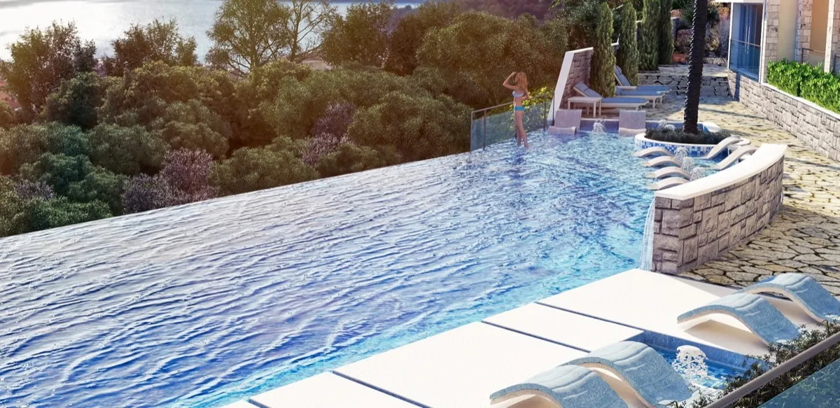 Großer Infinity-Pool mit Sonnenliegen und Blick auf einen dichten Wald und ein Gewässer