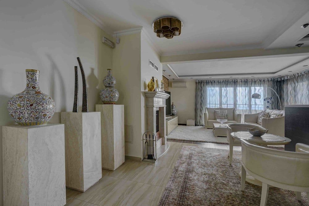 Przestronny salon z kominkiem i jasnymi meblami w willi w Sutomore, Czarnogóra: stylowe wnętrze z dekoracjami i panoramą.