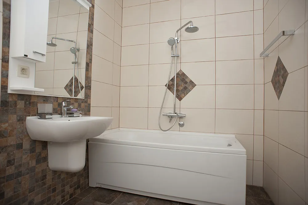 Helles Badezimmer mit weißer Sanitärkeramik und Fliesen im Mosaikstil in einer Villa in Perazića Do, Montenegro.