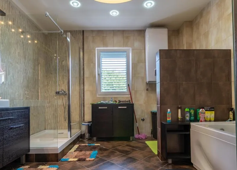 Modernes Badezimmer mit Duschkabine und Badewanne in einer Villa in Tivat, Montenegro, mit hochwertiger Fliesenverarbeitung.