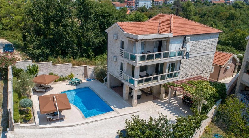 Dreistöckige Villa in Tivat, Montenegro, mit privatem Pool, Terrassen, Ruhebereich und Parkplätzen auf dem Grundstück.