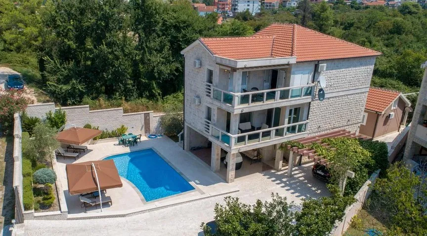 Dreistöckige Villa in Tivat, Montenegro, mit privatem Pool, Terrassen, Ruhebereich und Parkplätzen auf dem Grundstück.