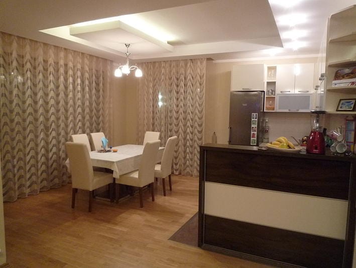 Nowoczesny salon z jadalnią w domu w Zelenice, Czarnogóra: jasne meble, barek i panoramiczne zasłony.