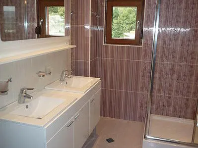 Bathroom with two sinks and a shower cabin in a house, Zelenika, Montenegro. Modern tile finish.