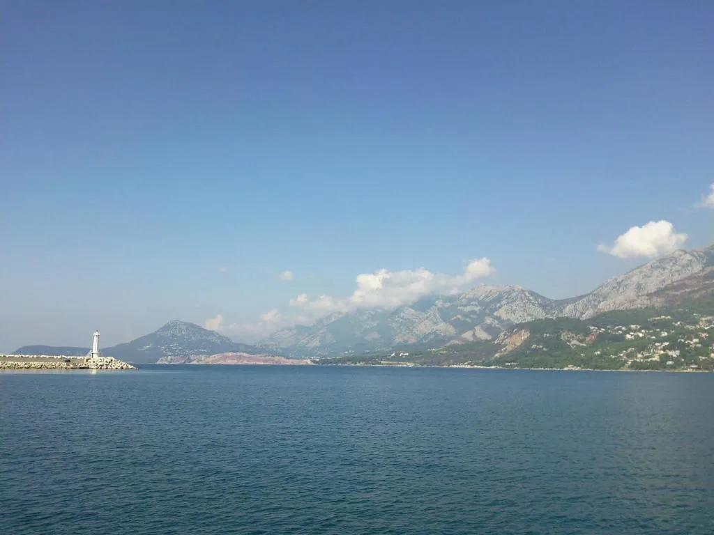 Panoramablick auf das Meer, die Berge und den Leuchtturm in Šušanj, Bar Riviera, Montenegro. Malerische Meereslandschaft.