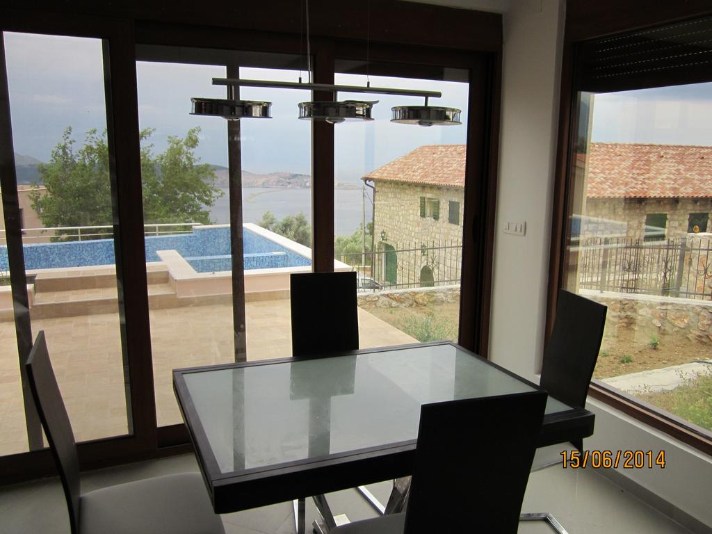 Wohnzimmer mit Panoramafenstern, Esstisch und Blick auf den Pool und das Meer in einem Haus, Bar-Riviera, Montenegro.