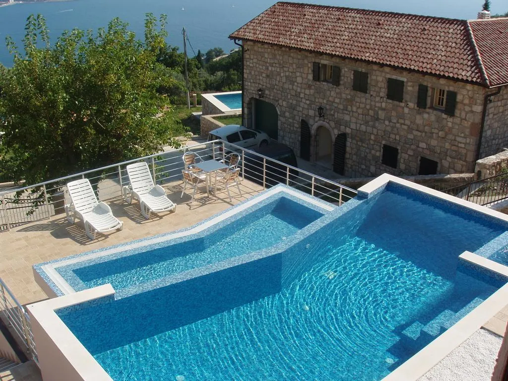Pool mit Meerblick bei der Steinvilla in Šušanj, Bar Riviera, Montenegro: Terrasse mit Liegestühlen und Ruhebereich.