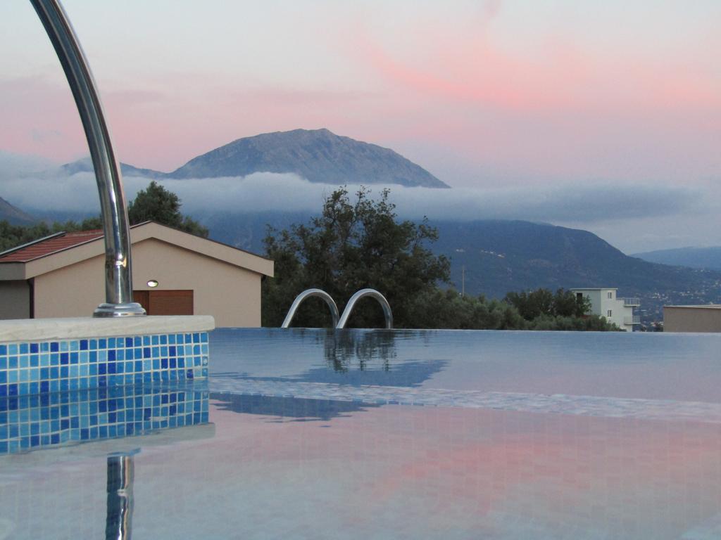 Infinity-Pool mit Blick auf die Berge und den Sonnenuntergang in einem Haus in Šušanj, Bar-Riviera, Montenegro.