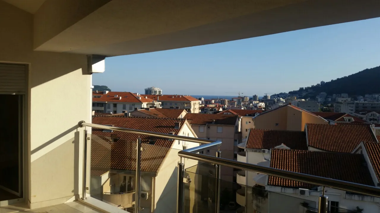 Blick vom Balkon der Wohnung in Budva, Montenegro: Panorama der Stadt mit Ziegeldächern und Meereshorizont.