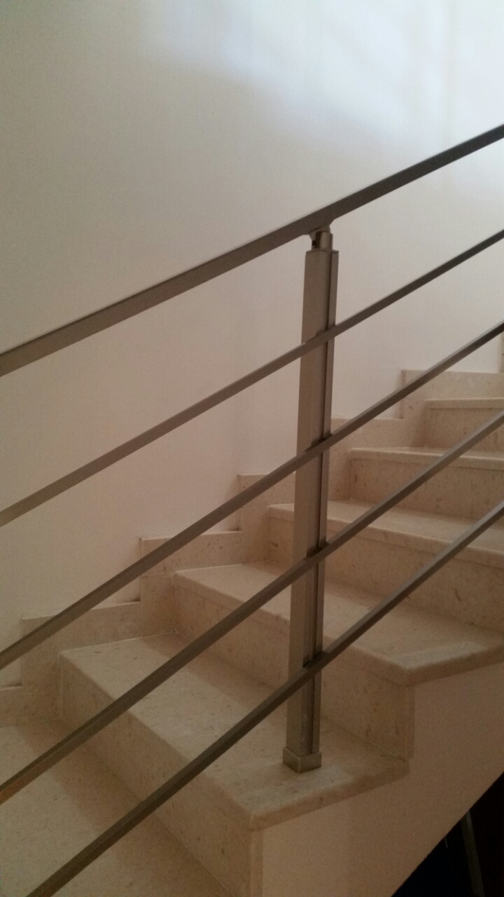 Stepenište od svetlog kamena sa modernim metalnim ogradama u stanu, Budva, Crna Gora.