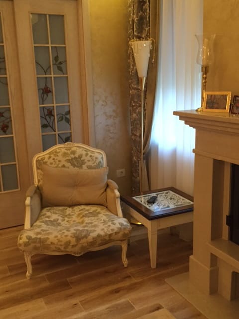 Cozy living room in a house in Zelenika, Montenegro: an armchair with floral upholstery, a fireplace, and a classic-style interior.