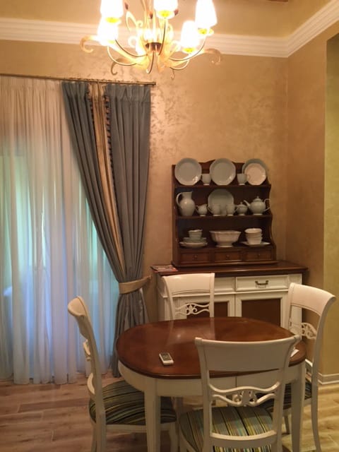 Cozy dining area in a house in Zelenika, Montenegro: a wooden table, a vintage sideboard with dishes, and classic decor.