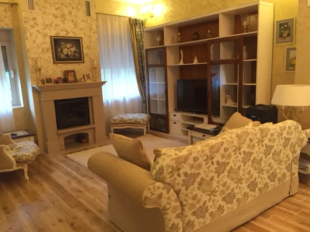 Przytulny salon z kominkiem i miękkimi meblami w domu, Zelenika, Czarnogóra. Klasyczne wnętrze z drewnianą podłogą.