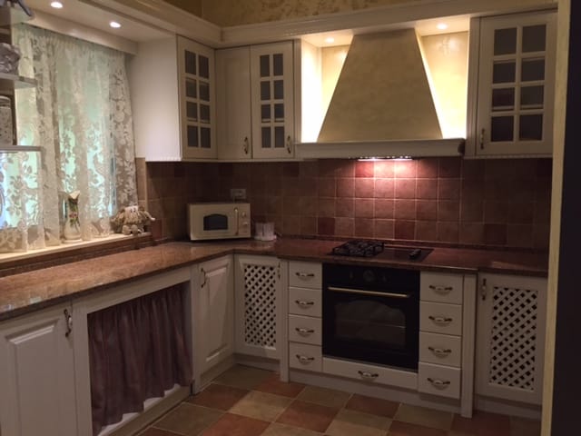 Classic kitchen in a house in Zelenika, Montenegro: light-colored cabinetry, granite countertop, and built-in appliances.