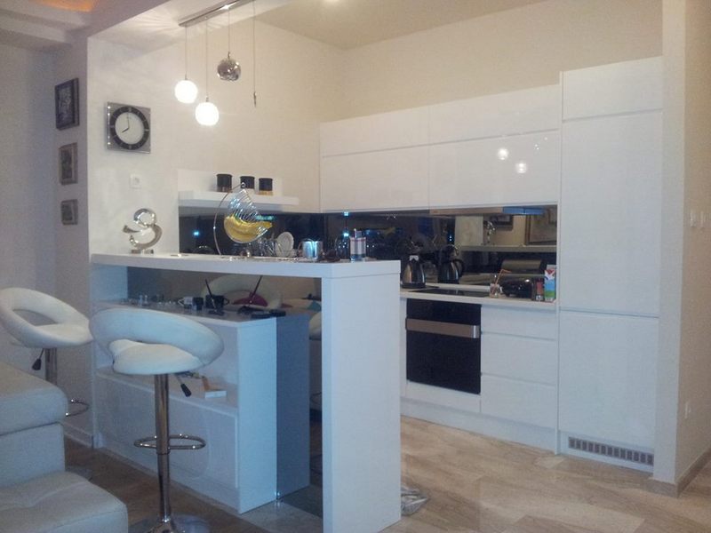 Bar tezgahlı ve ankastre cihazlı modern beyaz mutfak, dairede, Budva şehri, Karadağ.