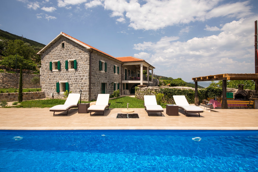 Steinvilla mit Pool, Sonnenliegen und Grillbereich auf der Halbinsel Luštica, Montenegro.