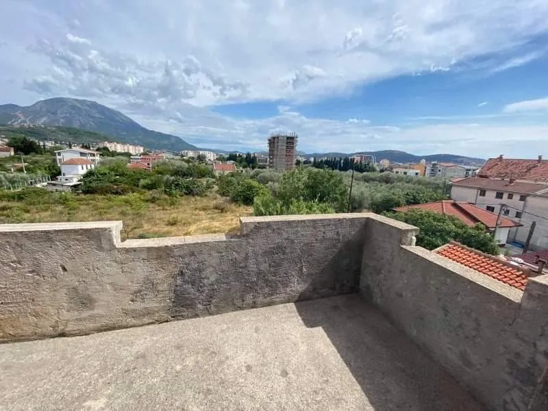 Otvorena terasa kuće u Šušnju, Crna Gora, sa panoramskim pogledom na planine, maslinjake i gradsku izgradnju.