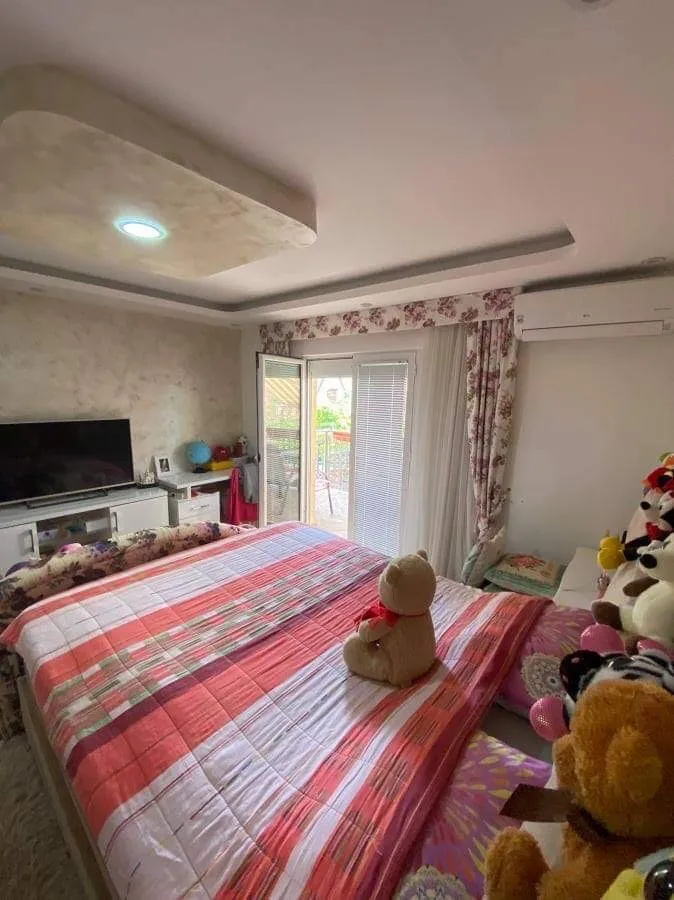 Udobna spavaća soba sa bračnim krevetom i izlazom na balkon u kući, Šušanj, Crna Gora. Moderan enterijer sa TV-om.