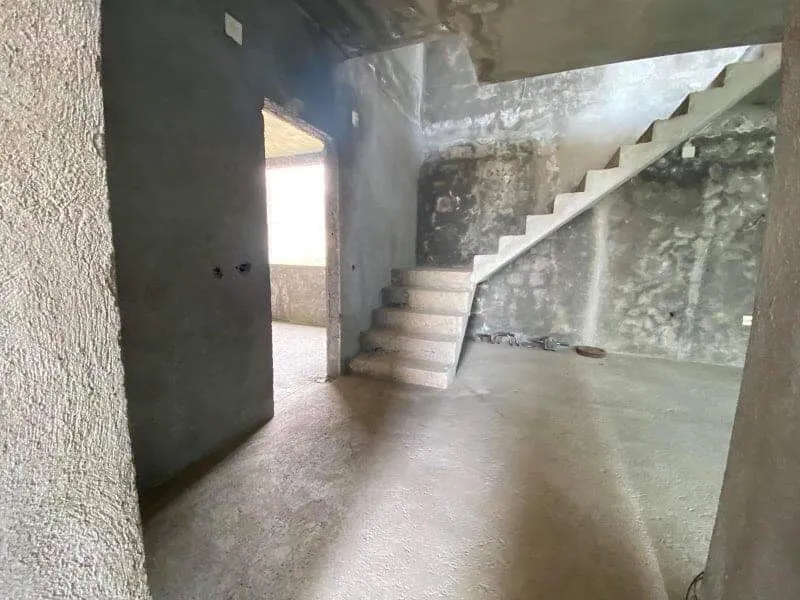 Dnevna soba u kući bez završne obrade sa betonskim stepeništem na sprat, prodaja nekretnine u Šušnju, Crna Gora.