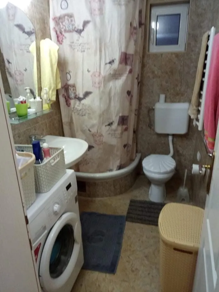 Kupatilo u kući u Šušnju, Crna Gora: tuš kabina, veš mašina, sanitarije i pločice.