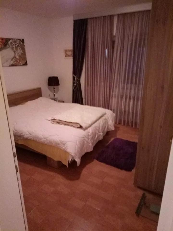 Ugodna spavaća soba sa bračnim krevetom i ormarom u kući, Šušanj, Crna Gora. Svetao enterijer sa pločicama na podu.