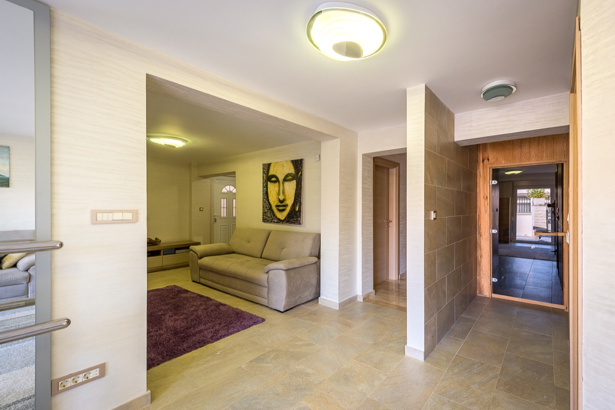 Wohnzimmer mit Sofa und Sauna in einer modernen Villa in Krašići, Montenegro: stilvolles Interieur mit Fliesen und Dekor.