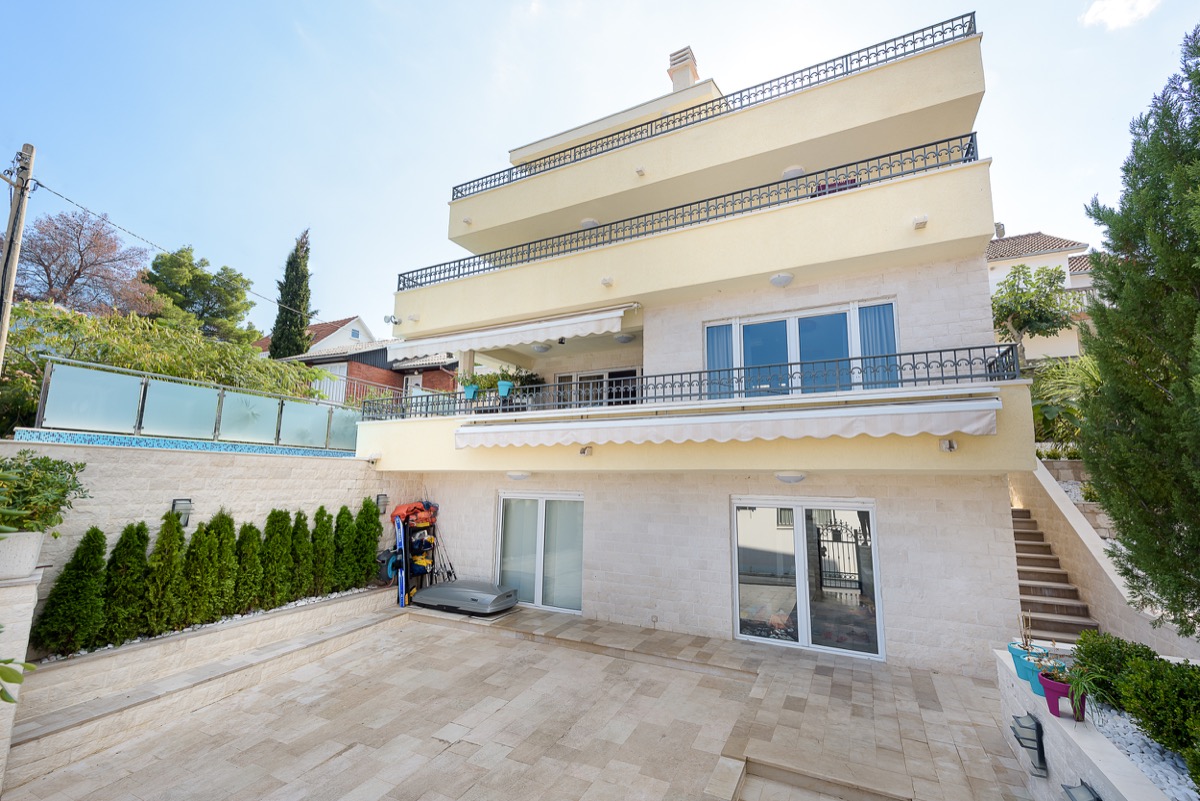 Dreistöckige Villa in Krašići, Montenegro: Steinfassade, Terrassen mit schmiedeeisernen Geländern und ein gemütlicher Innenhof.