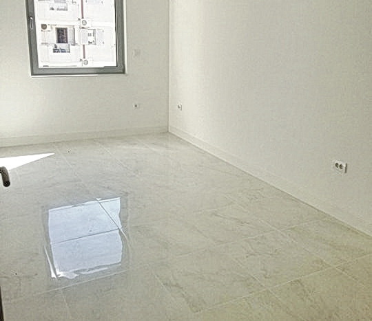 Budva, Karadağ’daki yeni konut kompleksinde porselen seramik kaplamalı aydınlık oturma odası.