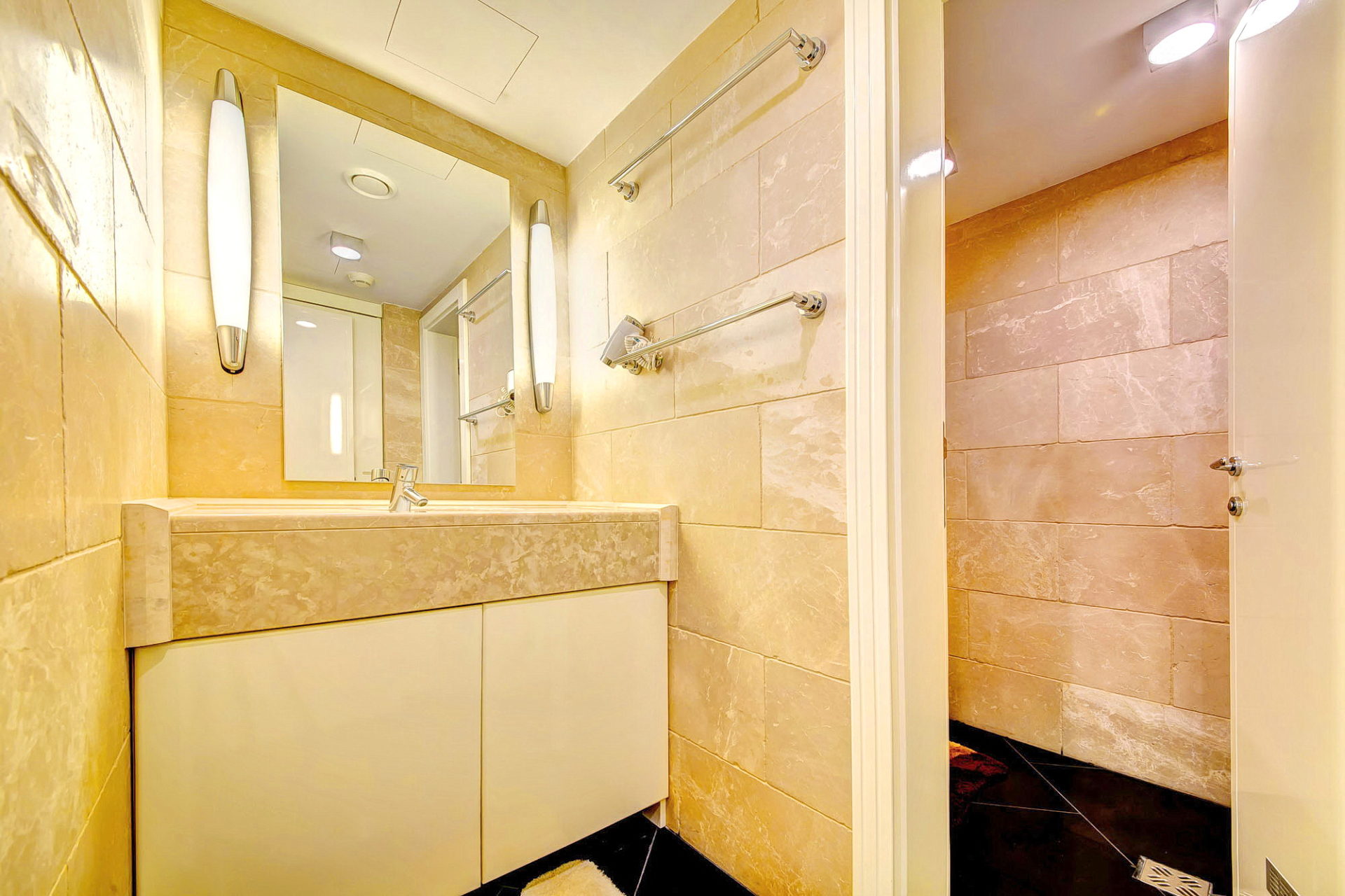 Bej fayanslı ve duş kabinli modern banyo, Bečići, Karadağ’daki dairede.