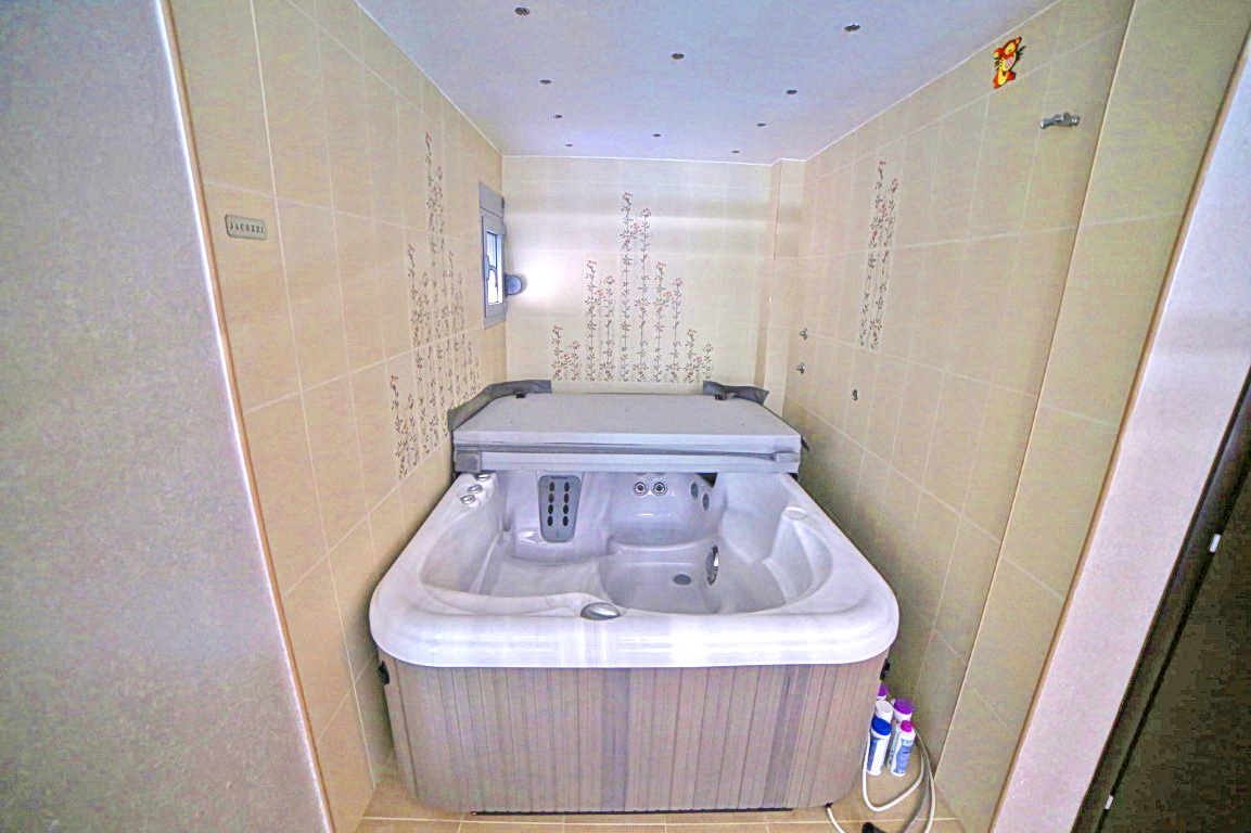 Badezimmer mit Whirlpool in einer Villa in Budva, Montenegro: helle Fliesen mit floralem Dekor und Spotbeleuchtung.