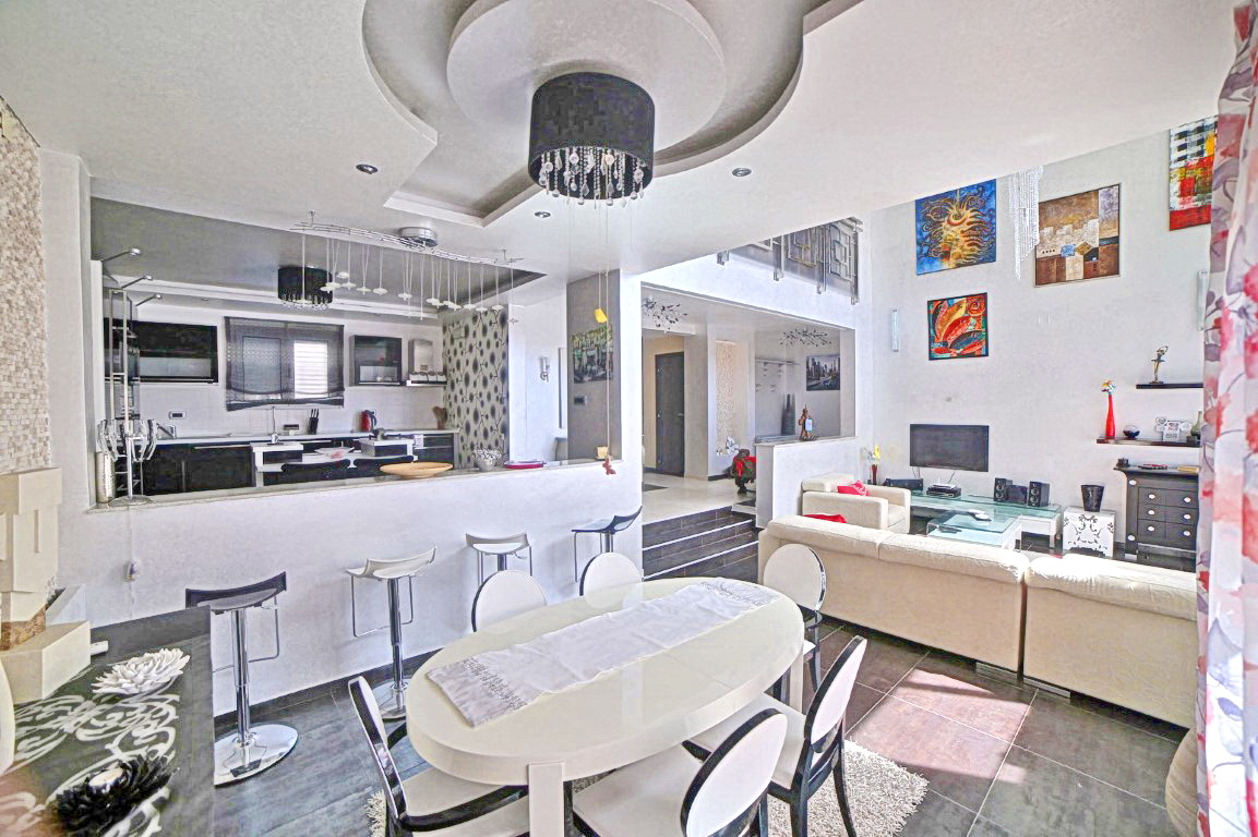 Modernes Wohnzimmer mit Essbereich und Küche in einer Villa in Budva, Montenegro: stilvolles Interieur, hohe Decken.