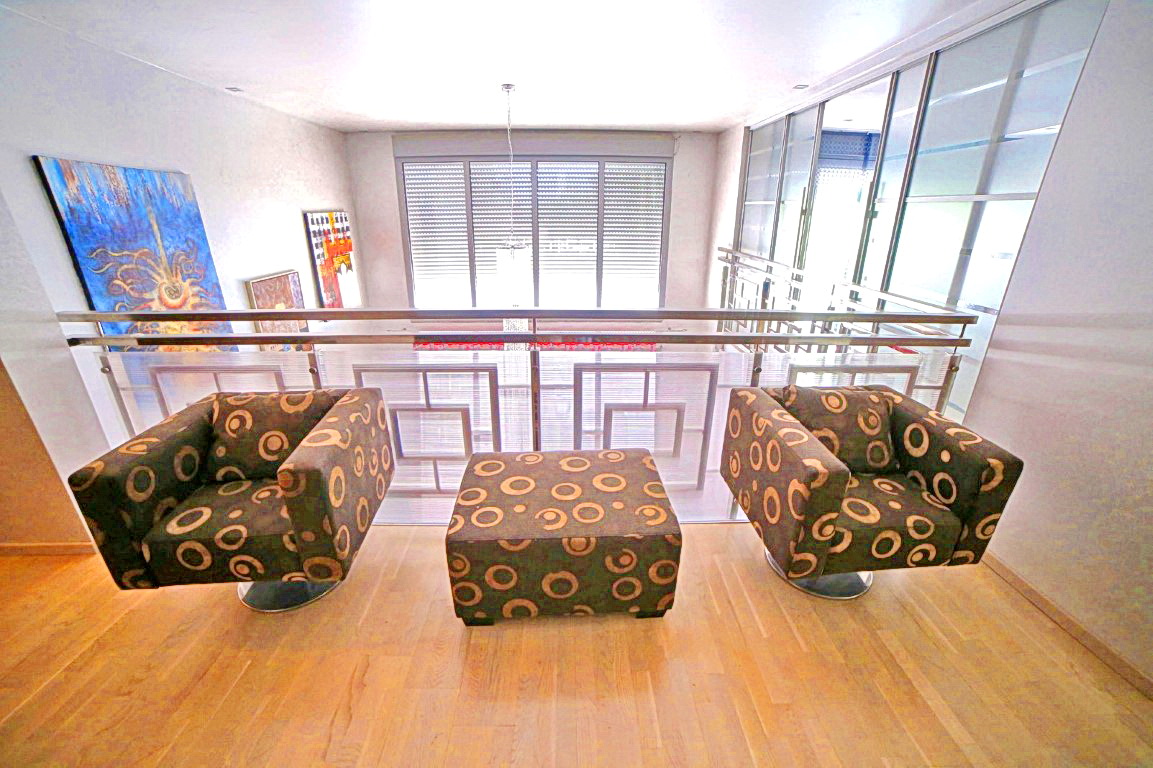Ruhebereich mit Sesseln in einer modernen Villa in Budva, Montenegro: Parkett, Panoramafenster und stilvolles Interieur.