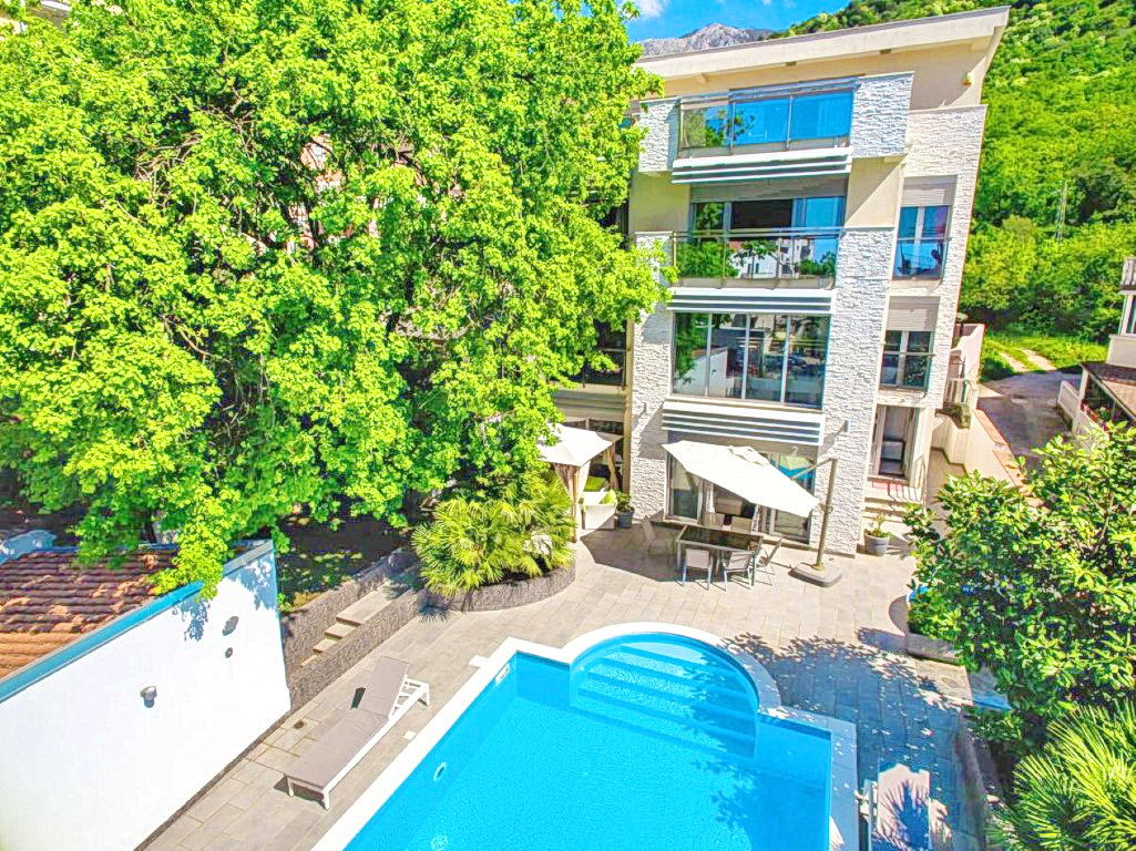 Moderne Villa mit Pool und Terrasse in Budva, Montenegro: Blick auf das Gebäude mit Panoramafenstern und grünem Garten.