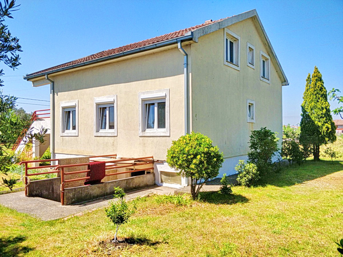 Dvospratna privatna kuća sa krovom od crepa i zelenim vrtom u Podgorici, Crna Gora, pogled na fasadu i dvorište oko kuće