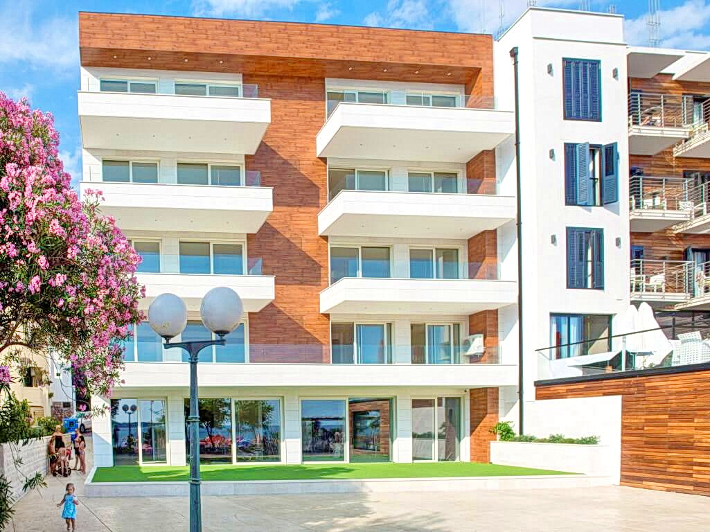 Karadağ, Rafailovići’de balkonlu modern konut kompleksi: ahşap kaplamalı ve panoramik pencereli cephe.