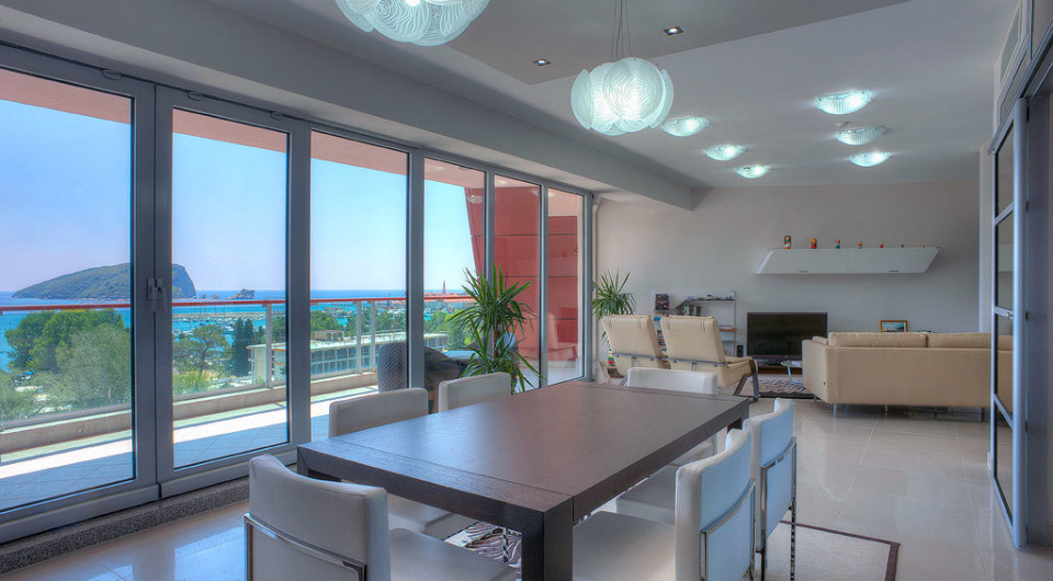 Modernes Wohnzimmer mit Panoramablick auf das Meer und die Insel in Budva, Montenegro: stilvolle Möbel und helles Interieur.