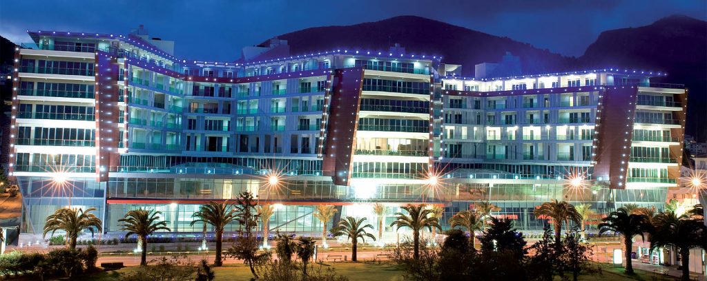 Moderner Wohnkomplex mit Nachtbeleuchtung und Panoramafenstern in der Stadt Budva, Montenegro.