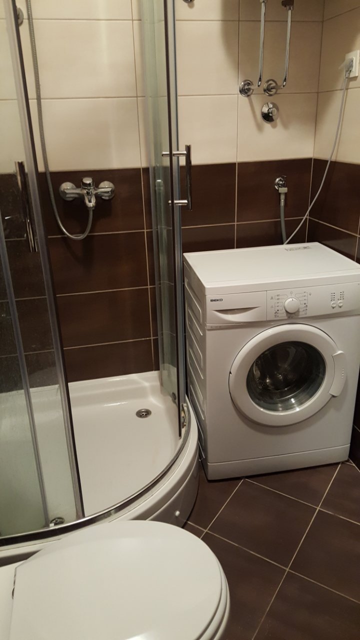 Budva, Karadağ’daki dairede banyo: duş kabini, Beko çamaşır makinesi ve fayans kaplama.